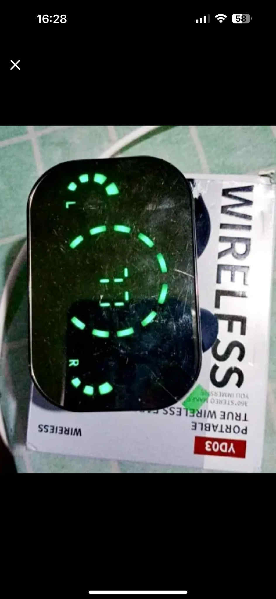 Digital clock with green display on a wireless charging pad packaging